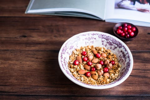 Granola o muesli casero con copos de avena, almendras, avellanas y arándanos frescos en un bol, enfoque selectivo