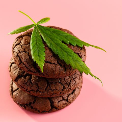 homemade marijuana chocolate cookies with green leaf on pink background