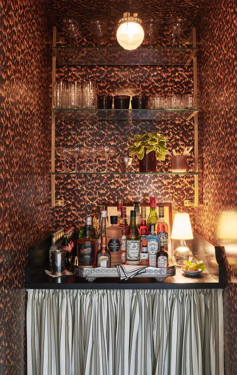 a sexy tortoiseshell wallpaper and antiqued gold shelving dress up an alcove bar for cocktail hour