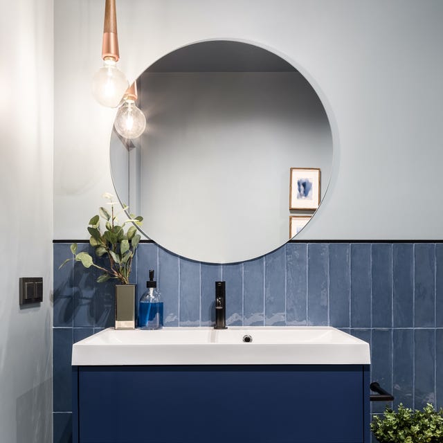 designed bathroom with stylish blue cabinet and blue wall tiles