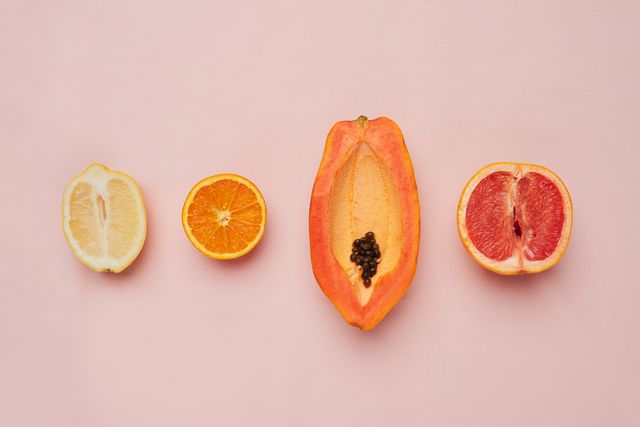 studio shot of a row of fruit against a pink background