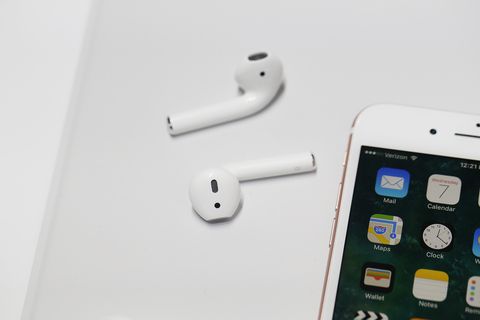 airpods sitting on a white table next to an iphone