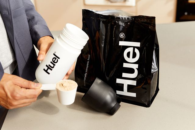 man putting huel powder into huel cup