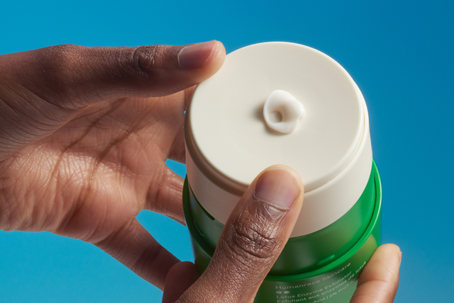 two hands squeezing lotion out of humanscale bottle