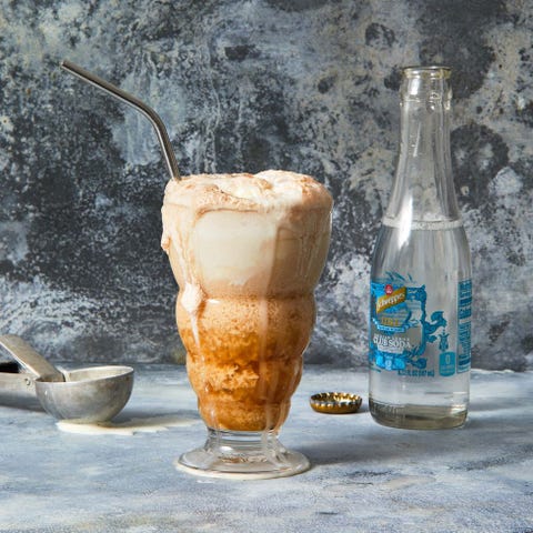 a tall ice cream float with a metal straw