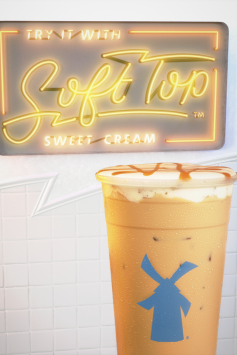 a neon sign behind an iced coffee beverage