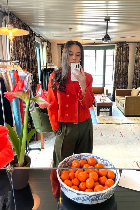 bazaar editor jaclyn alexandra cohen tries on an orange high sport jacquard jacket while standing in the high sport showroom