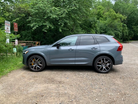 volvo xc60 recharge viewed from the side parked next to woods