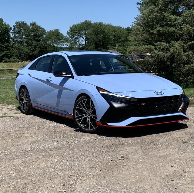 hyundai elantra n parked in a dirt lot with a field in the background