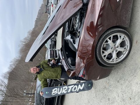 Corvette c8 dans un parking de domaine skiable avec un snowboarder