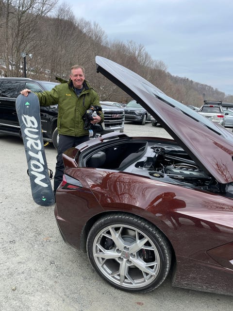 corvette c8 in a ski park parking lot with a skier