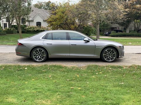genesis g90 parked next to a park