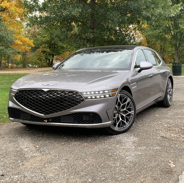 genesis g90 parked on side of the road next to a park