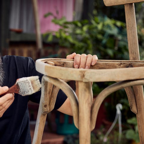 diy in the garden man painting wooden chair