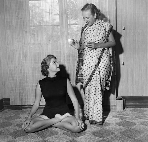 indra devi instructs a student on a yoga position in her hollywood studio in 1952