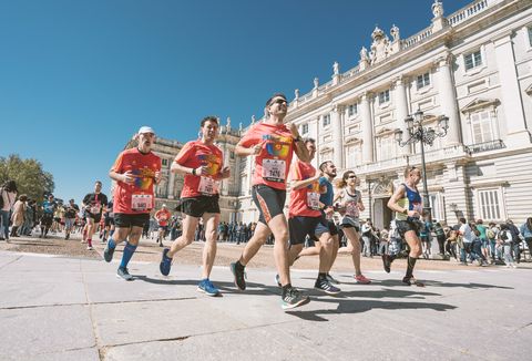 varios corredores pasan por delante del palacio real durante el maratón de madrid 2019