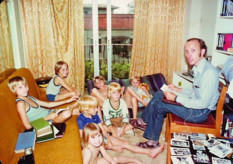 a man reads to a crowd of children