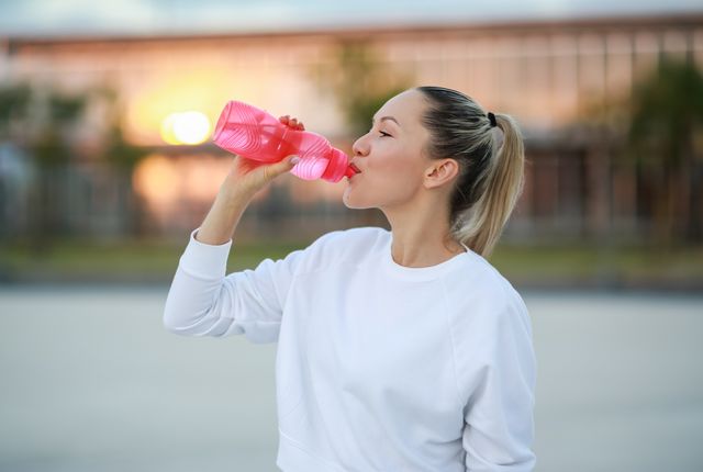 vrouw drinkt water tijdens het sporten