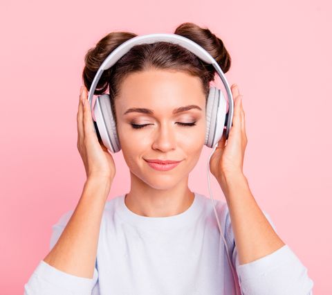 Close-up portrait of nice lovely sweet attractive calm peaceful conecnrated focused girl wearing touching earphones closed eyes isolated over pink pastel background