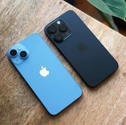 two iphones with the camera side facing up on desk
