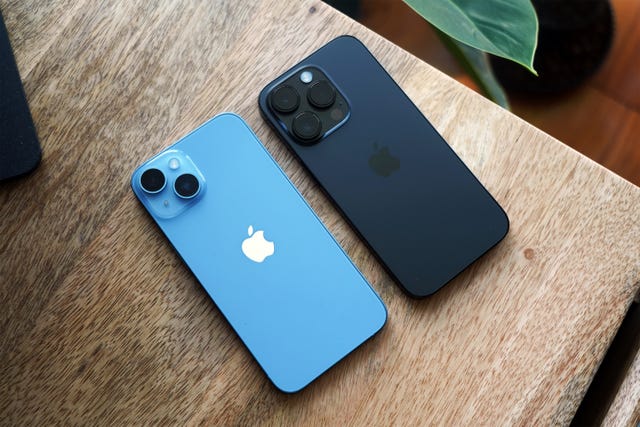 two iphones with the camera side facing up on desk
