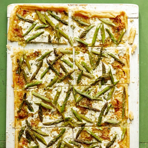 cheesy asparagus tart on white wood board