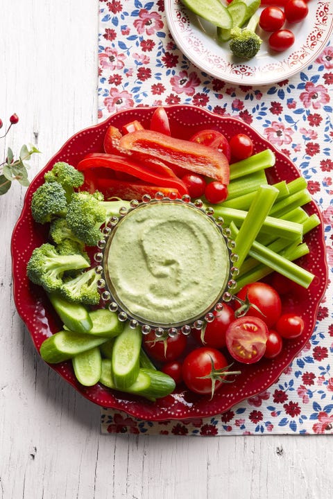 crudites with herby dip on red plate