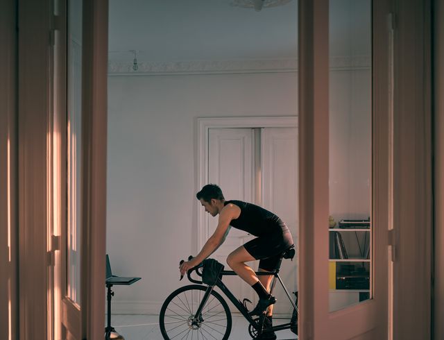 shot of a young man working out on an exercise bike at home