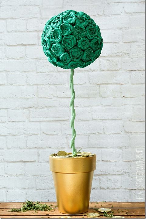 topiary made with green crepe paper rosettes in a painted gold pot sprinkled with gold coins