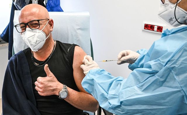 un italiano saluda al ser vacunado contra la covid 19