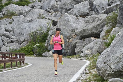 Italy, Trentino, woman running on road near Lake Garda