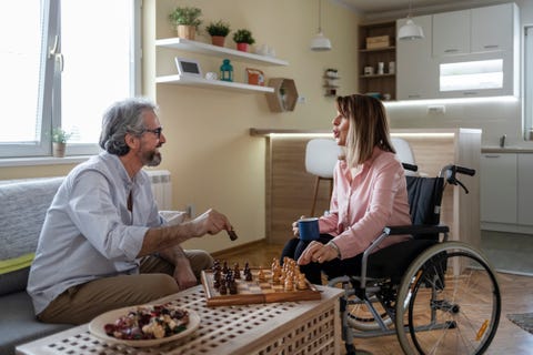 man and woman in a wheelchair playing chess