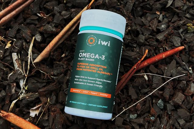 a bottle of iwi life omega 3 supplements on a mulchy background