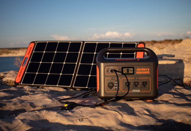 jackery power outlet and solar panel in sand