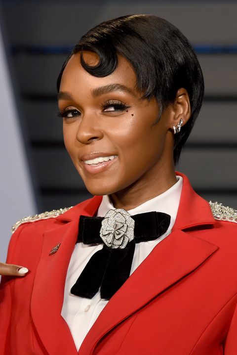 janelle monae in a red blazer with black bow and a slicked down pixie