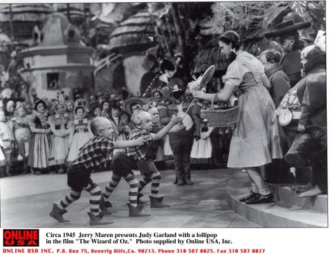 Jerry Maren presents Judy Garland with a lollipop in the film "The Wizard of Oz."