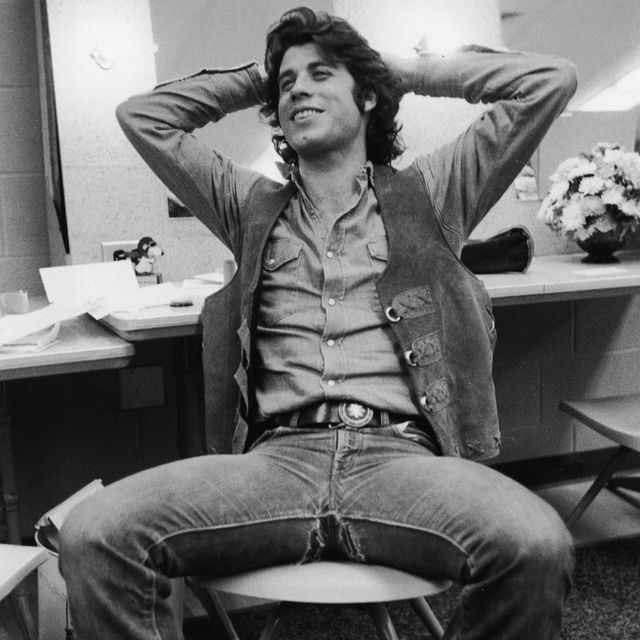 american actor john travolta sits in a chair and leans back with his hands behind his head, late 1970s photo by hulton archivegetty images