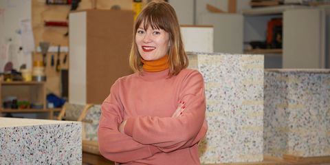 een portret van modeontwerper joline jolink in een roze trui in haar atelier