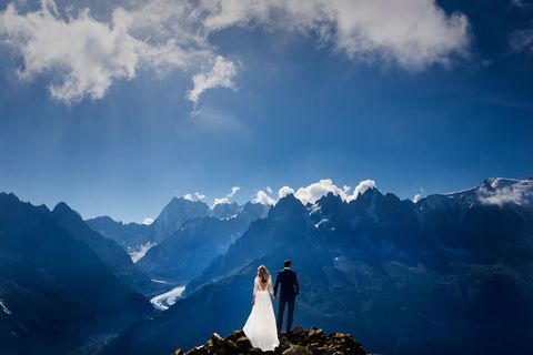 Sky, Dress, Mountainous landforms, Bridal clothing, Bride, Gown, Mountain, Wedding dress, Marriage, Mountain range, 