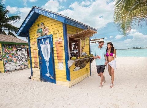 a couple walking along junkanoo beach in the bahamas