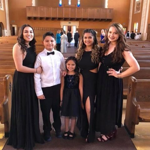 five children posing in formal wear at a church