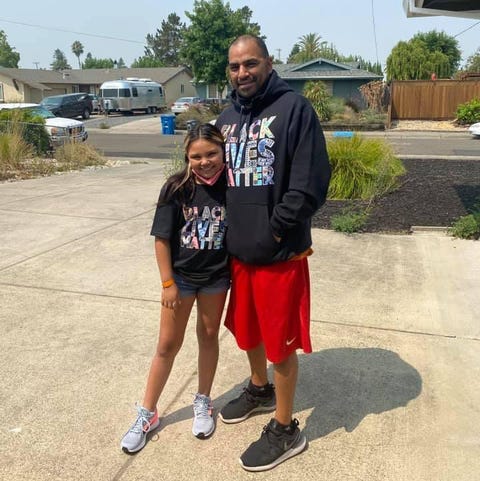 father and daughter posing wearing black lives matter t shirts