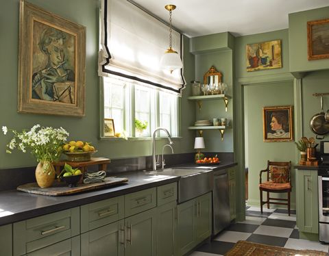 a kitchen with green cabinets and black countertops and a checkerboard floor