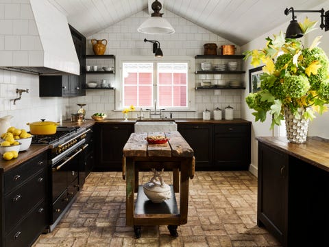 ceiling height wall tiles in alternating dimensions and reclaimed brick flooring and oak countertops anchor the kitchen in beautiful rusticity