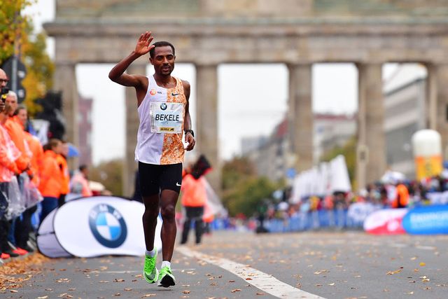 el atleta etíope kenenisa bekele celebra su victoria en el maratón de berlín 2019 saludando con la mano delante de la puerta de brandemburgo tras quedarse a dos segundos del récord mundial de eliud kipchoge