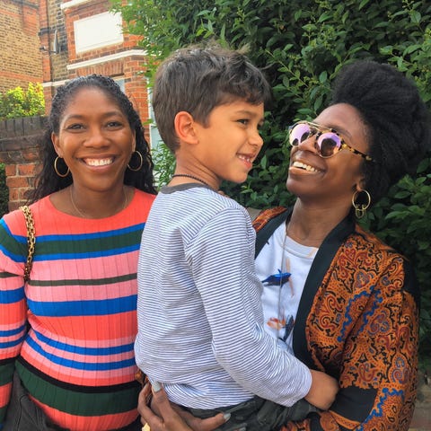 two smiling women pose with a little boy