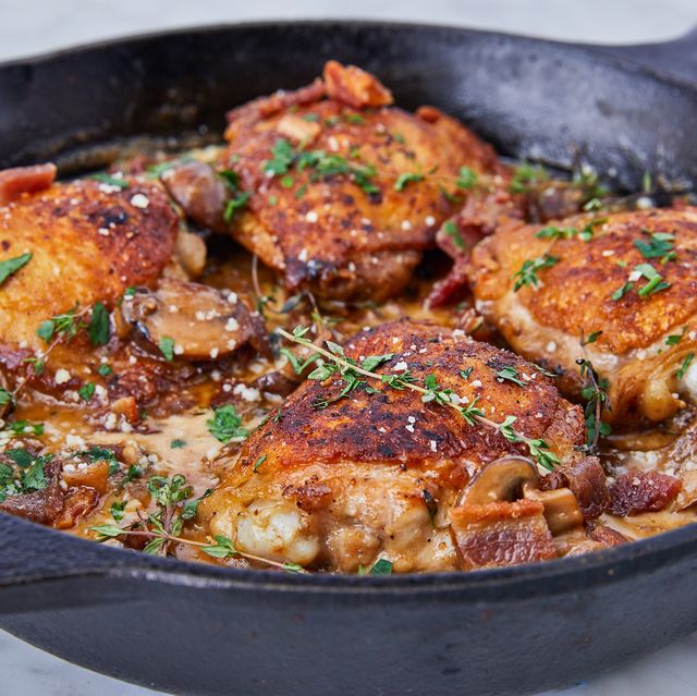 keto chicken thighs garnished with thyme in a black cast iron pan