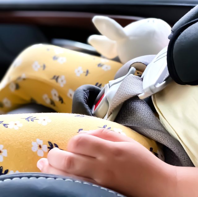 kid holding stuffed animal in car seat