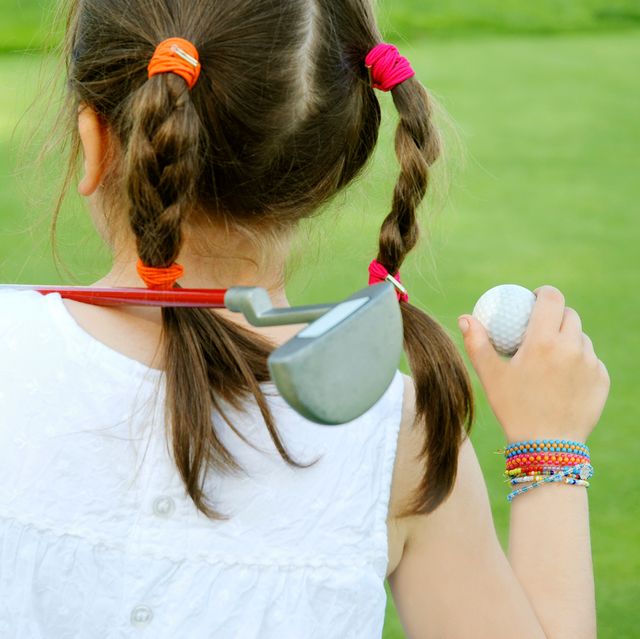 young girl with golf club and ball