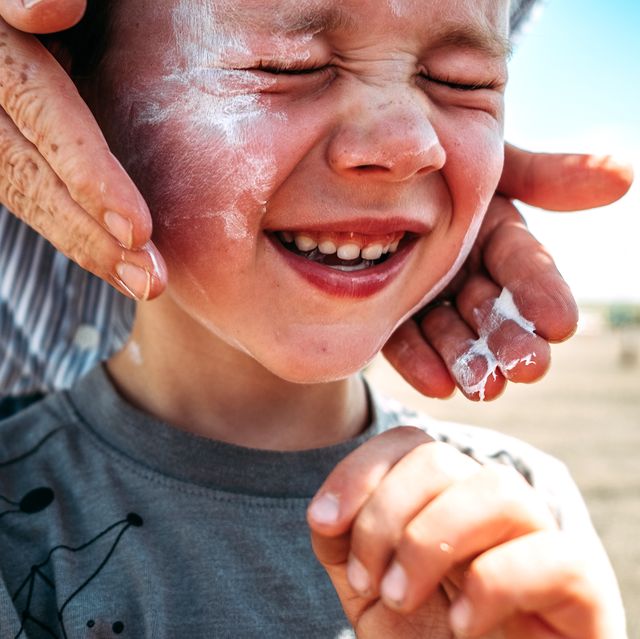 parent applying sunscreen to kid's face